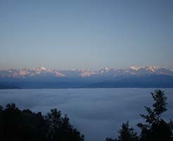 Sunrise in the Himalayas seen from the farm. The valley below is covered in fog early morning.